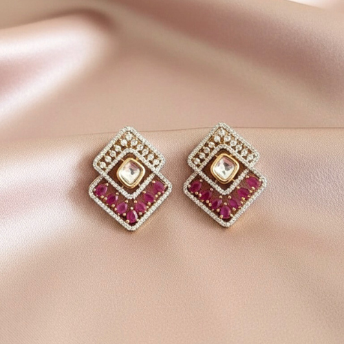 Geometric layered stud earrings with pink stones and American diamonds, set in a gold and silver frame without back clips, displayed on a satin nude background.