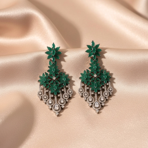 Green floral earrings on a beige satin background